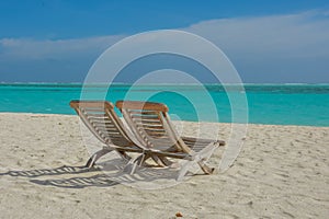 Beautiful topical view of the beach with wooden chairs