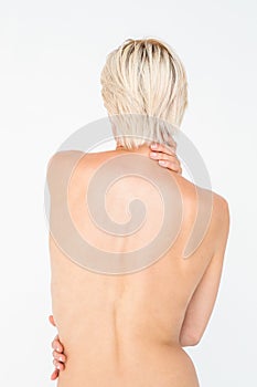 Beautiful topless woman touching her back