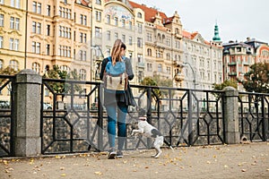 A beautiful tourist girl with a backpack admiring the ancient architecture of Prague in the Czech Republic. Next to the