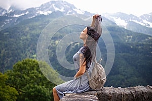 Beautiful tourist girl with backpack at mountains