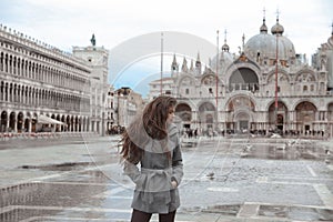 Beautiful tourist girl with long wavy hair in Piazza San Marco i