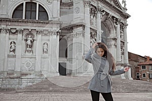 Beautiful tourist girl visiting famous landmark of Basilica Santa Maria della Salute, Venice, Italy