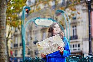 Beautiful tourist in Paris on a fall day, using map
