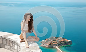 Beautiful tourist relax over Sveti Stefan island in Budva, Montenegro. brunette traveller girl visiting Adriatic Sea, Balkan