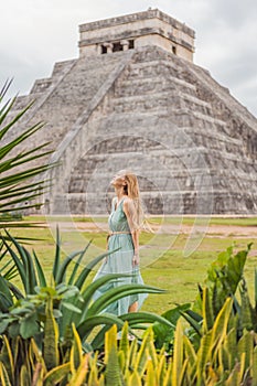 Beautiful tourist woman observing the old pyramid and temple of the castle of the Mayan architecture known as Chichen