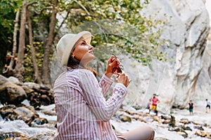 Beautiful tourist woman sitting and resting while she is hiking in nature. Wanderlust concept.