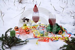 Beautiful toys on the branches of a festively decorated Christmas tree and a glass of drink on the table