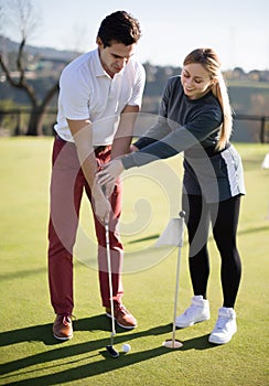 Beautiful trainer showing player how to hit ball