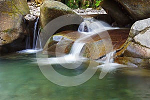 Beautiful tranquil waterfall among the rocks of mountain creek