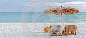 Beautiful tranquil white sand beach with two beach chair and thatched umbrella with copy space. romantic summer vacation