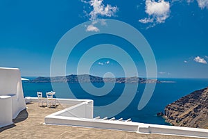 Beautiful travel background, two white chairs with white architecture on Santorini island, Greece. Luxury couple destination