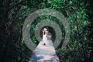 Beautiful traveller woman in white dress, sneaker and straw hat