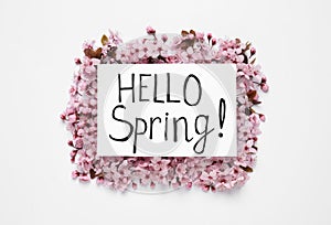 Beautiful tree blossoms and card with text Hello Spring on white background, top view