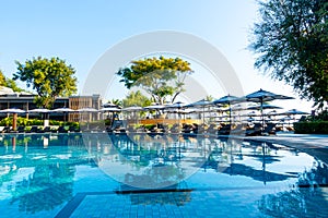 Beautiful tropical beach and sea with umbrella and chair around swimming pool in hotel resort for travel and vacation