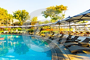 Beautiful tropical beach and sea with umbrella and chair around swimming pool in hotel resort for travel and vacation