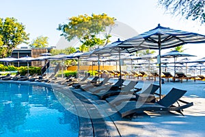 Beautiful tropical beach and sea with umbrella and chair around swimming pool in hotel resort for travel and vacation