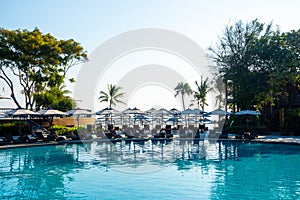 Beautiful tropical beach and sea with umbrella and chair around swimming pool in hotel resort for travel and vacation