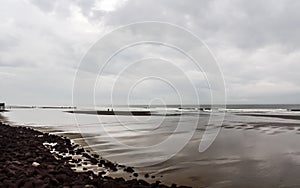 Beautiful tropical beach sunset sky and ocean wave forms a quiet silence atmospheric emotion on a rainy cloudy overcast day.