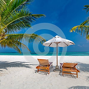 Beautiful tropical island scenery, two sun beds, loungers, umbrella under palm tree. White sand, sea view with horizon