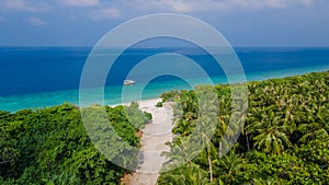 Beautiful tropical landscape with sandy road leading to the beach at the island Manadhoo the capital of Noonu atoll