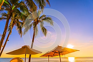 Beautiful tropical nature umbrella chair with palm tree around beach sea ocean at sunset or sunrise