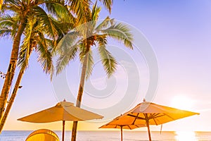 Beautiful tropical nature umbrella chair with palm tree around beach sea ocean at sunset or sunrise