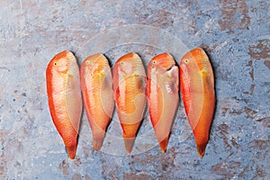 Beautiful tropical red sea fish Pearly razorfish on a blue background. Xyrichtys novacula, seafood from Mediterranean Sea. Fish