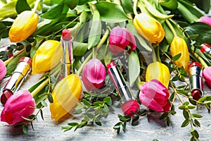 Beautiful tulips with different lipsticks on light background