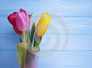 Beautiful tulips fresh vase, lovely birthday on a blue wooden background