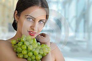 Beautiful turkish woman holding a bunch of grapes