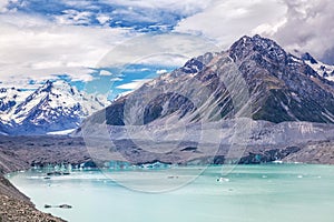 Beautiful turqouise Tasman Glacier Lake and Rocky Mountains in the clouds
