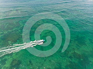 Beautiful turquoise ocean water with boat on it top view aerial photo.