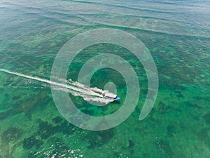 Beautiful turquoise ocean water with boat on it top view aerial photo.