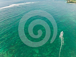 Beautiful turquoise ocean water with boat on it top view aerial photo.