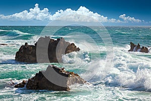 Beautiful Turquoise Ocean Waves, rocks coastline and blue sky photo