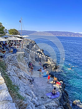 Beautiful turquoise rocky seascape with a famous swimming place full of tourists and visitors near Hydronetta coctail bar in Hydra