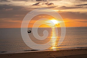 Beautiful twilight golden sun light sunset in sea behind island. silhouette fisherman boat. calm and romantic place in thailand