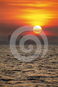 Beautiful twilight sunrise in the morning at Thailand paradise sea bay with cloud sky and big city silhouette town building