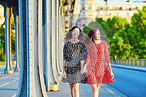 Beautiful twin sisters on the Bir Hakeim bridge in Paris, France