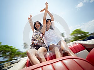 Beautiful twin sisters having fun in cabriolet car