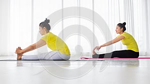 The beautiful of two Asian women are exercise yoga in the yoga room for good health and flexibility of the muscles with feel good