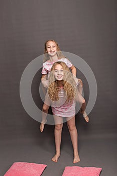 Beautiful two girls in pink pajamas play before going to bed