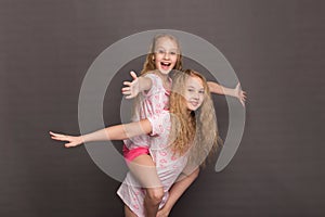 Beautiful two girls in pink pajamas play before going to bed