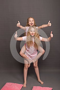 Beautiful two girls in pink pajamas play before going to bed