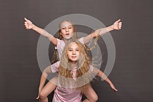 Beautiful two girls in pink pajamas play before going to bed