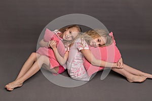 Beautiful two girls in pink pajamas play before going to bed