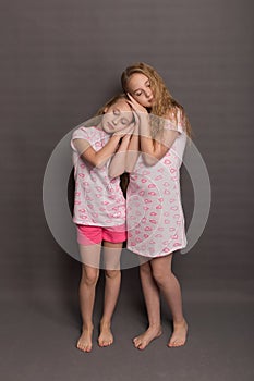 Beautiful two girls in pink pajamas play before going to bed