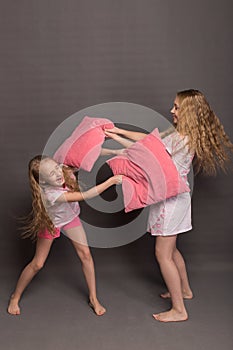 Beautiful two girls in pink pajamas play before going to bed