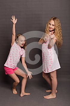 Beautiful two girls in pink pajamas play before going to bed