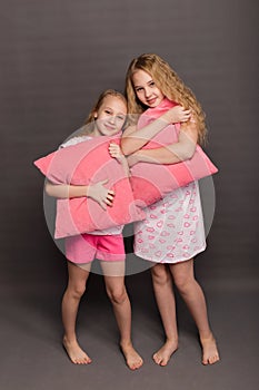 Beautiful two girls in pink pajamas play before going to bed